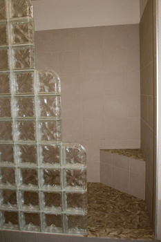 The floor and walls of the shower in the master bathroom are tiled and is separated with a glass wall